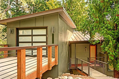 Diseño de fachada de casa verde moderna de tamaño medio de tres plantas con revestimiento de madera, tejado de un solo tendido y tejado de metal