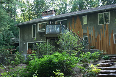 Diseño de fachada de casa multicolor rural de tamaño medio de dos plantas con revestimiento de madera y tejado de teja de madera