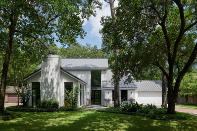 Diseño de fachada de casa blanca contemporánea de tamaño medio de dos plantas con revestimientos combinados, tejado a dos aguas y tejado de metal