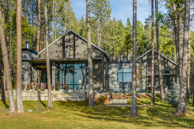 Inspiration pour une grande façade de maison marron chalet en bois de plain-pied avec un toit à deux pans et un toit en métal.