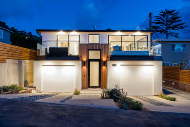 Mid-sized white two-story wood house exterior photo in Orange County with a hip roof, a metal roof and a gray roof