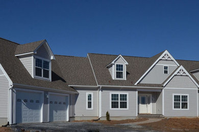 Foto de fachada de casa gris tradicional renovada de tamaño medio a niveles con revestimiento de vinilo, tejado a dos aguas y tejado de teja de madera