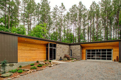 Foto de fachada de casa moderna de una planta con revestimiento de metal, tejado plano y tejado de metal