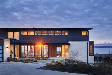 Inspiration for a mid-sized modern black three-story wood house exterior remodel in Seattle with a shed roof