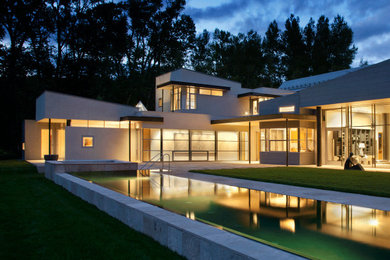 Immagine della facciata di una casa grande bianca contemporanea a due piani con rivestimento in stucco e copertura in metallo o lamiera