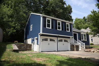 Example of a mid-sized classic blue split-level vinyl house exterior design in Boston with a clipped gable roof and a shingle roof
