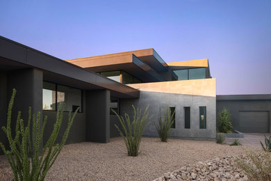 Example of a large trendy brown two-story stucco exterior home design in Phoenix with a metal roof