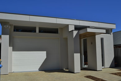 Diseño de fachada beige moderna de tamaño medio de dos plantas con revestimiento de ladrillo y tejado plano
