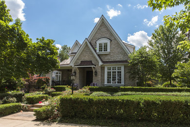 This is an example of a traditional two floor house exterior in Chicago with stone cladding and a pitched roof.