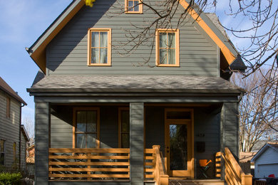 Modelo de fachada de casa gris tradicional de dos plantas con tejado a dos aguas y tejado de teja de madera