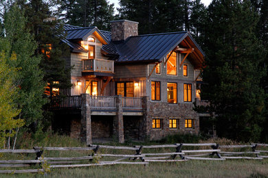 This is an example of a green rustic two floor house exterior in Denver with wood cladding.