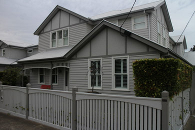 Exemple d'une grande façade de maison grise chic en bois à un étage avec un toit à deux pans.