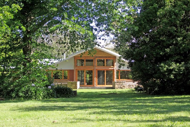 Exempel på ett mellanstort rustikt brunt trähus, med allt i ett plan och sadeltak