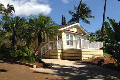 ハワイにあるお手頃価格の中くらいなビーチスタイルのおしゃれな家の外観 (コンクリート繊維板サイディング、黄色い外壁) の写真