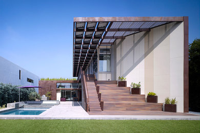 Cette image montre une grande façade de maison multicolore design en panneau de béton fibré avec un toit plat et un toit végétal.