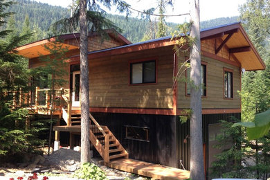 Inspiration for a rustic green two-story mixed siding gable roof remodel in Vancouver