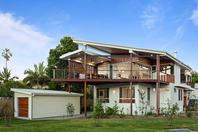 Ejemplo de fachada de casa multicolor marinera de dos plantas con revestimientos combinados y tejado de un solo tendido