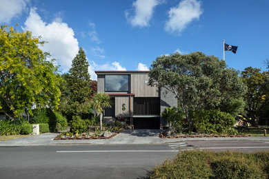 Inspiration for an expansive industrial concrete detached house in Auckland with three floors.