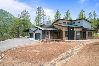 Example of a mid-sized mountain style gray two-story mixed siding house exterior design in Albuquerque with a shed roof and a metal roof