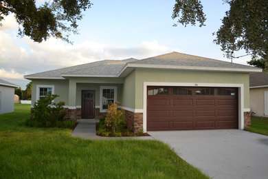 Example of a mid-sized transitional green one-story stucco exterior home design in Tampa with a hip roof