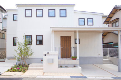 Photo of a white traditional two floor house exterior in Kobe with wood cladding and a flat roof.
