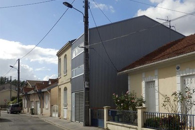 Aménagement d'une petite façade de maison de ville métallique et grise industrielle à deux étages et plus avec un toit à deux pans et un toit en métal.