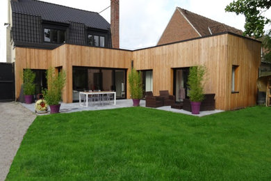 Exemple d'une façade de maison tendance en bois de taille moyenne avec un toit plat.