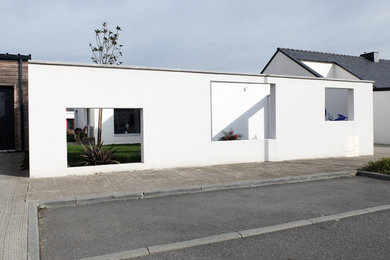 Diseño de fachada de casa blanca moderna pequeña de una planta con revestimiento de hormigón y tejado plano