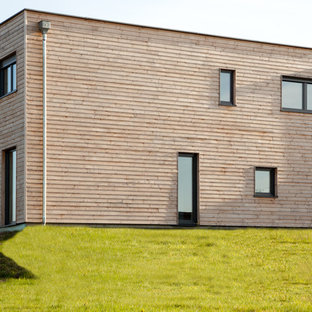 Réalisation d'une façade en bois marron minimaliste de taille moyenne et à un étage avec un toit plat.