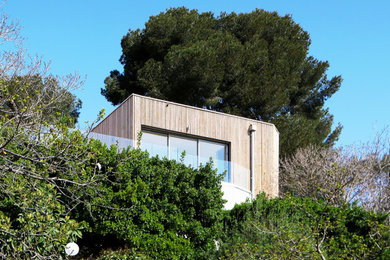Idée de décoration pour une grande façade de maison design en bois à un étage avec un toit plat.