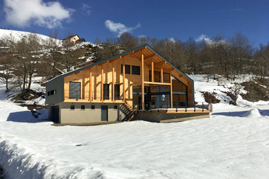 Aménagement d'une façade de maison montagne en bois de taille moyenne et à un étage avec un toit à deux pans.