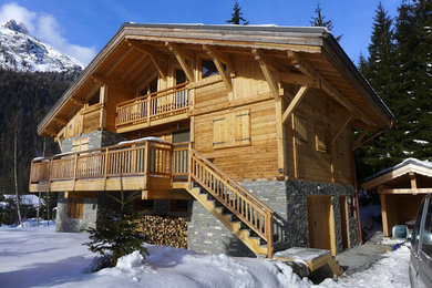 Cette photo montre une façade de maison marron tendance en bois de taille moyenne et à deux étages et plus avec un toit à deux pans.