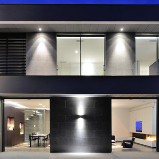 Réalisation d'une façade en pierre grise design de taille moyenne et à un étage avec un toit plat.