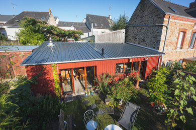 Diseño de fachada de casa pareada roja escandinava de tamaño medio de una planta con revestimiento de madera y tejado de metal