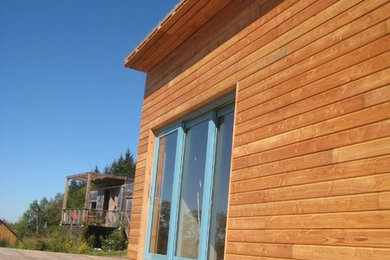Cette image montre une façade de maison design de taille moyenne et à un étage avec un toit plat.
