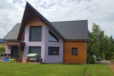 Réalisation d'une façade de maison multicolore chalet en bois à un étage avec un toit de Gambrel et un toit en tuile.