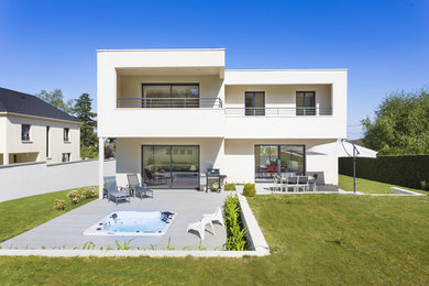 Exemple d'une grande façade de maison blanche moderne à un étage avec un toit plat et un toit végétal.