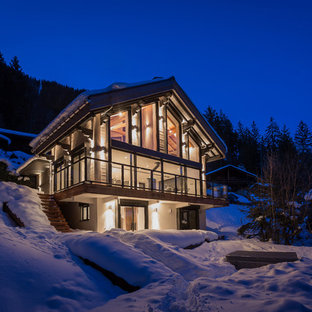 Réalisation d'une façade en verre chalet de taille moyenne et à deux étages et plus avec un toit à quatre pans.