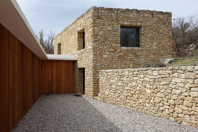 Ejemplo de fachada de casa bifamiliar beige rústica grande de dos plantas con revestimiento de piedra, tejado plano y tejado de varios materiales