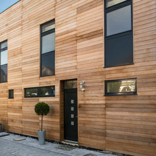 Aménagement d'une façade en bois marron contemporaine de taille moyenne et à un étage avec un toit plat.