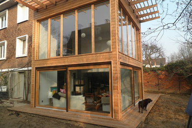 Idée de décoration pour une façade de maison marron design en bois de taille moyenne et à un étage avec un toit plat.