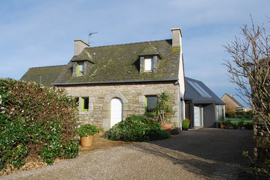 Cette photo montre une façade de maison nature en pierre de taille moyenne et à un étage avec un toit à deux pans.