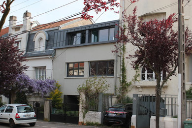 Aménagement d'une petite façade de maison métallique et beige contemporaine à deux étages et plus avec un toit plat.