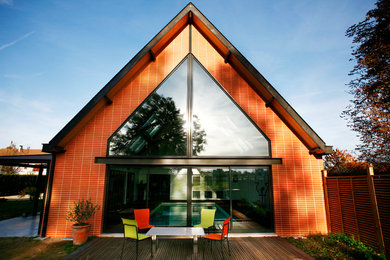 Aménagement d'une façade de maison contemporaine en brique de taille moyenne et de plain-pied avec un toit à deux pans.