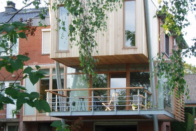 Idées déco pour une façade de maison de ville marron contemporaine en bois à un étage avec un toit plat et un toit en shingle.