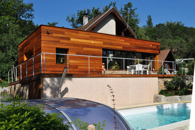 Exemple d'une façade de maison tendance en bois de taille moyenne et à un étage avec un toit plat.