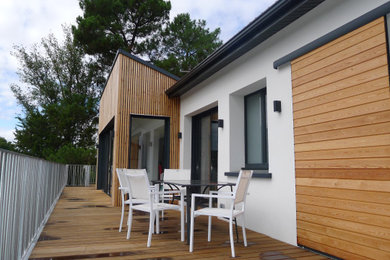 Idées déco pour une façade de maison blanche contemporaine en bois de taille moyenne et à deux étages et plus avec un toit à deux pans et un toit en tuile.