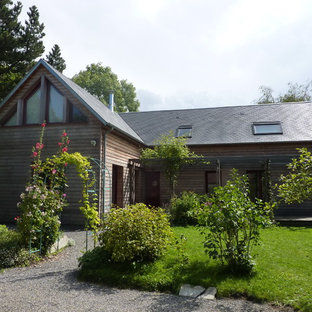 Cette photo montre une façade en bois marron nature de taille moyenne et à un étage avec un toit à deux pans.