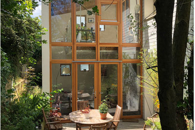 На фото: маленький, двухэтажный, стеклянный, белый частный загородный дом в стиле модернизм для на участке и в саду с
