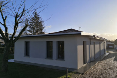 Foto de fachada de casa blanca actual pequeña de una planta con tejado a cuatro aguas, revestimiento de hormigón y tejado de varios materiales